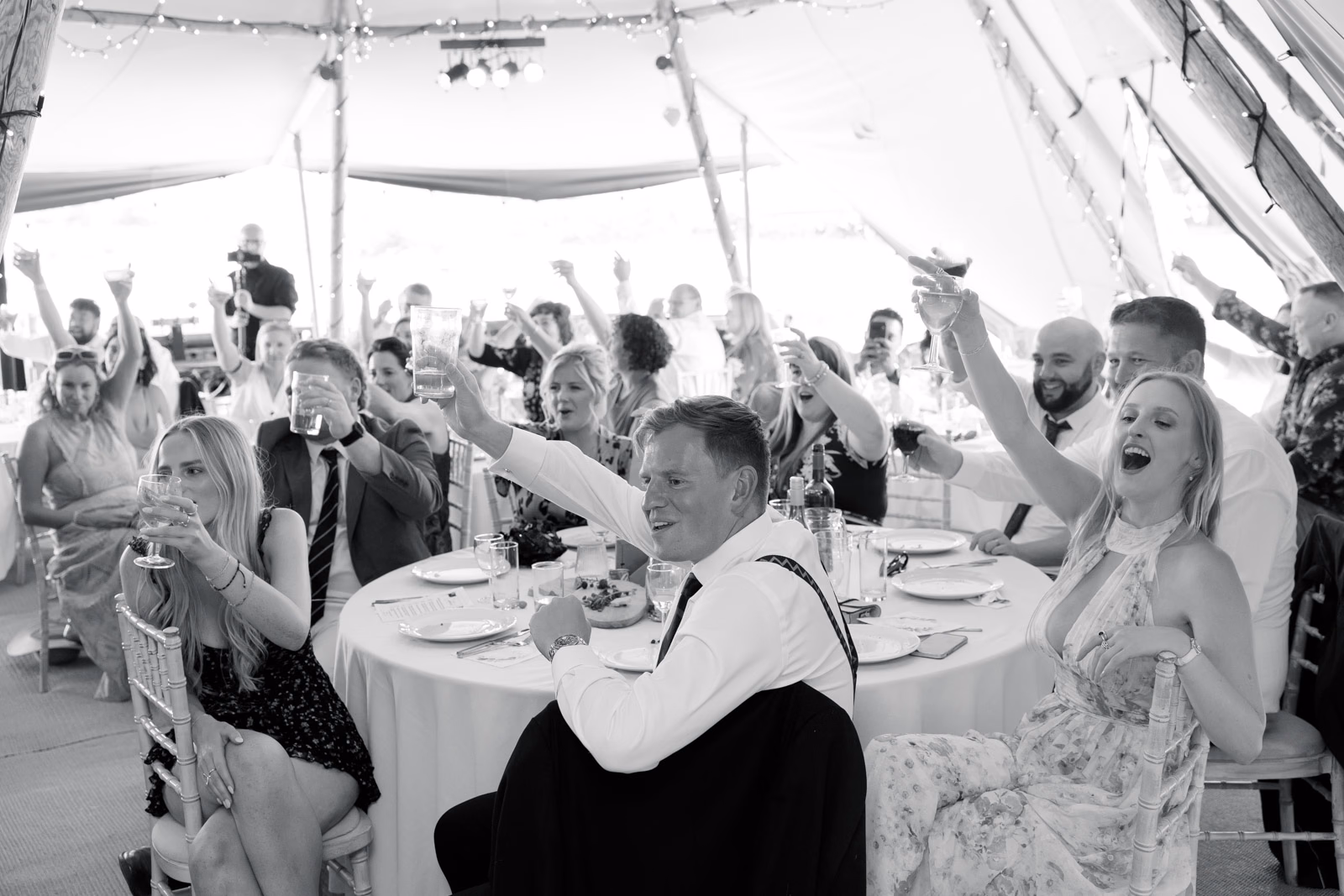 Guests cheering speeches black-and-white at a family farm wedding in Taunton