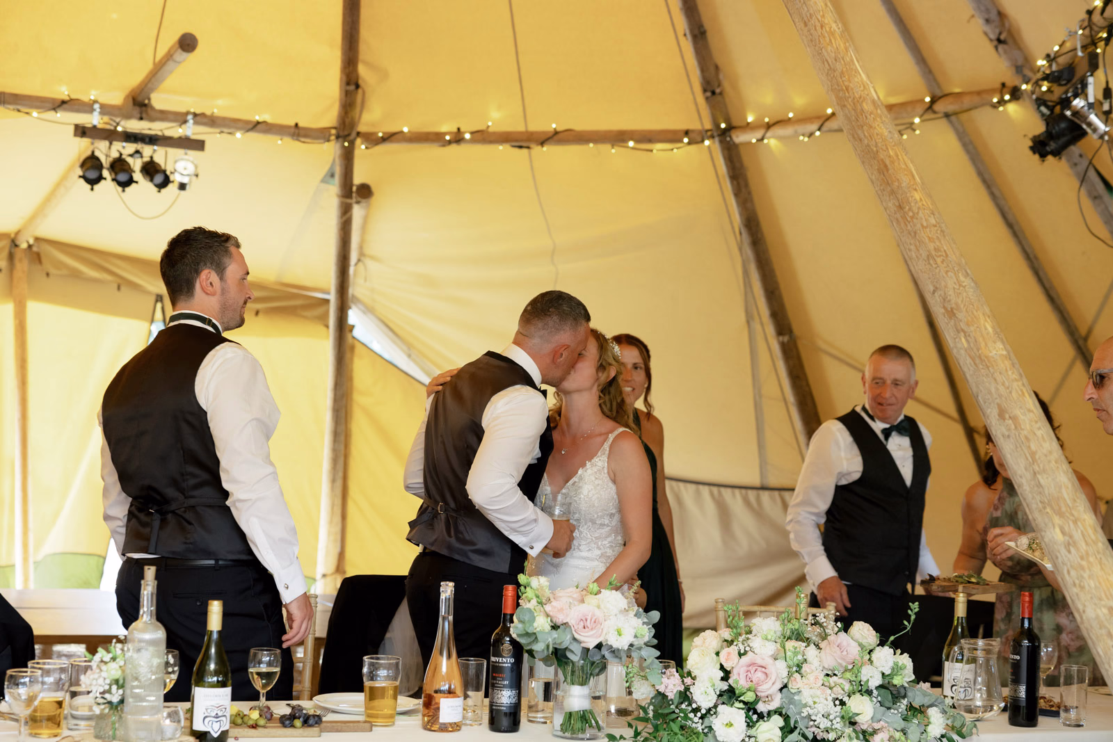 Bride and groom kiss top table at a Taunton farm wedding, photographed by Tanya Bogdan Photography