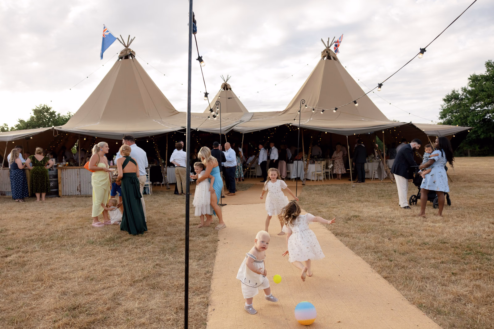 Children playing outside tipi evening at a countryside wedding in Taunton, Somerset