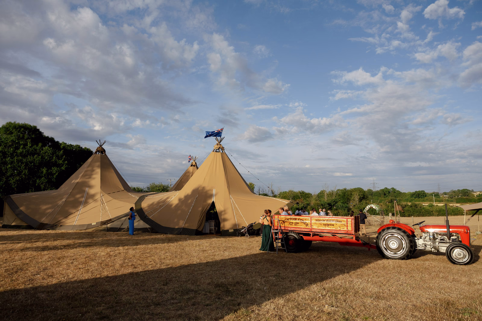 Tractor and tipis golden hour at a family farm wedding in Taunton