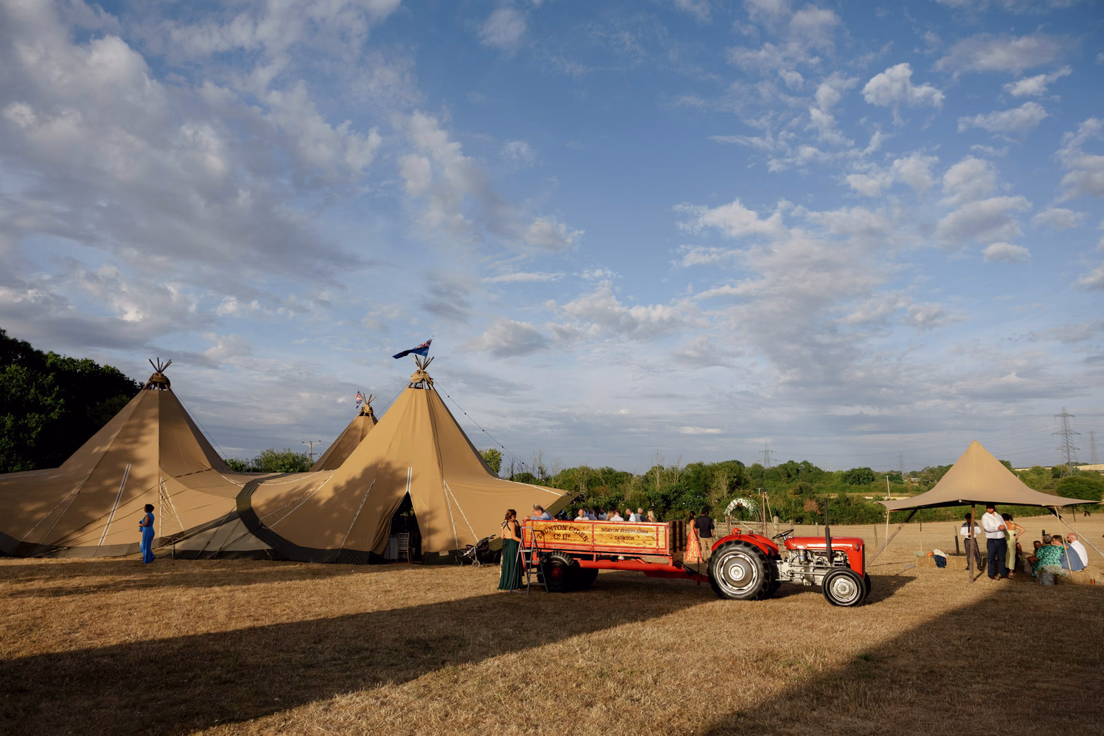 Tractor and tipis evening sky at a countryside wedding in Taunton, Somerset