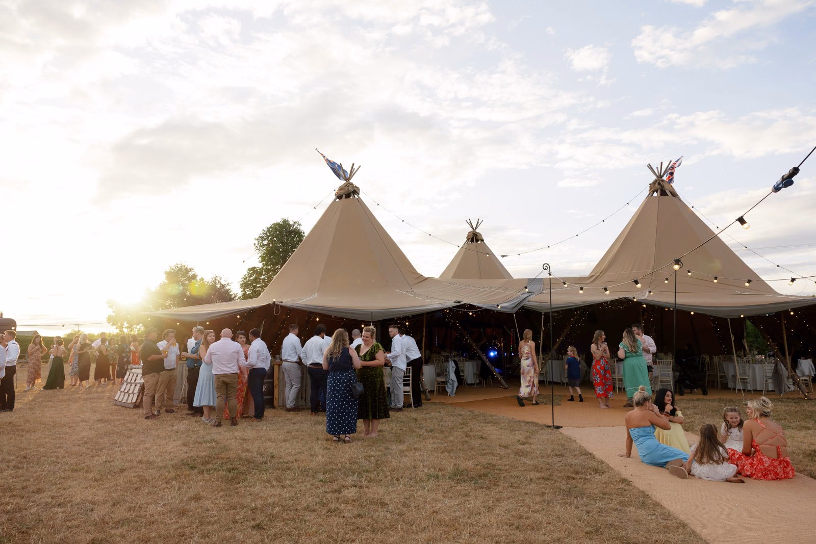 Tipi sunset guests gathering at a countryside wedding in Taunton, Somerset