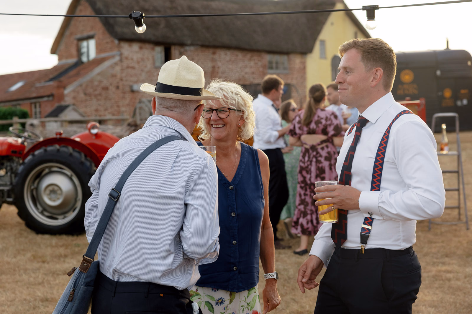 Guests chatting farm evening at a family farm wedding in Taunton
