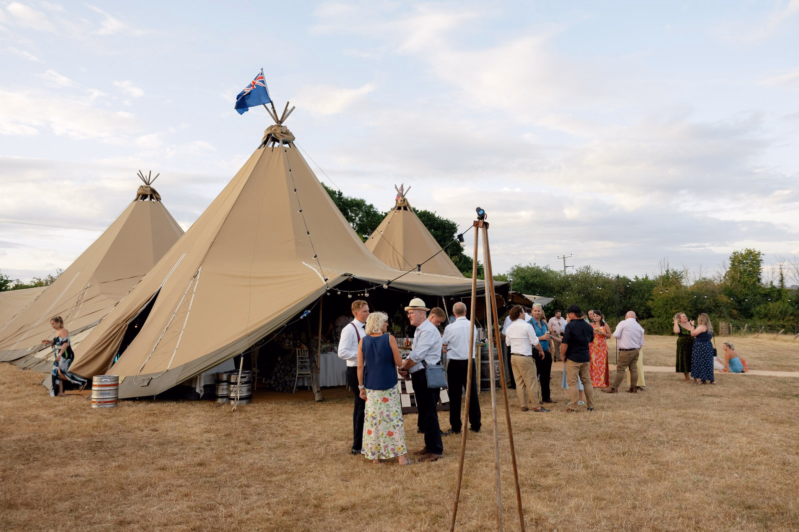 Tipi evening guests on lawn sunset at a Taunton farm wedding, photographed by Tanya Bogdan Photography