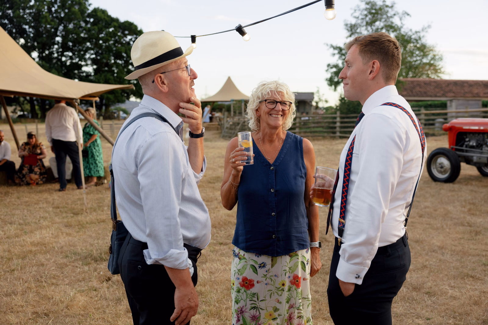 Guests chatting farm evening light at a family farm wedding in Taunton