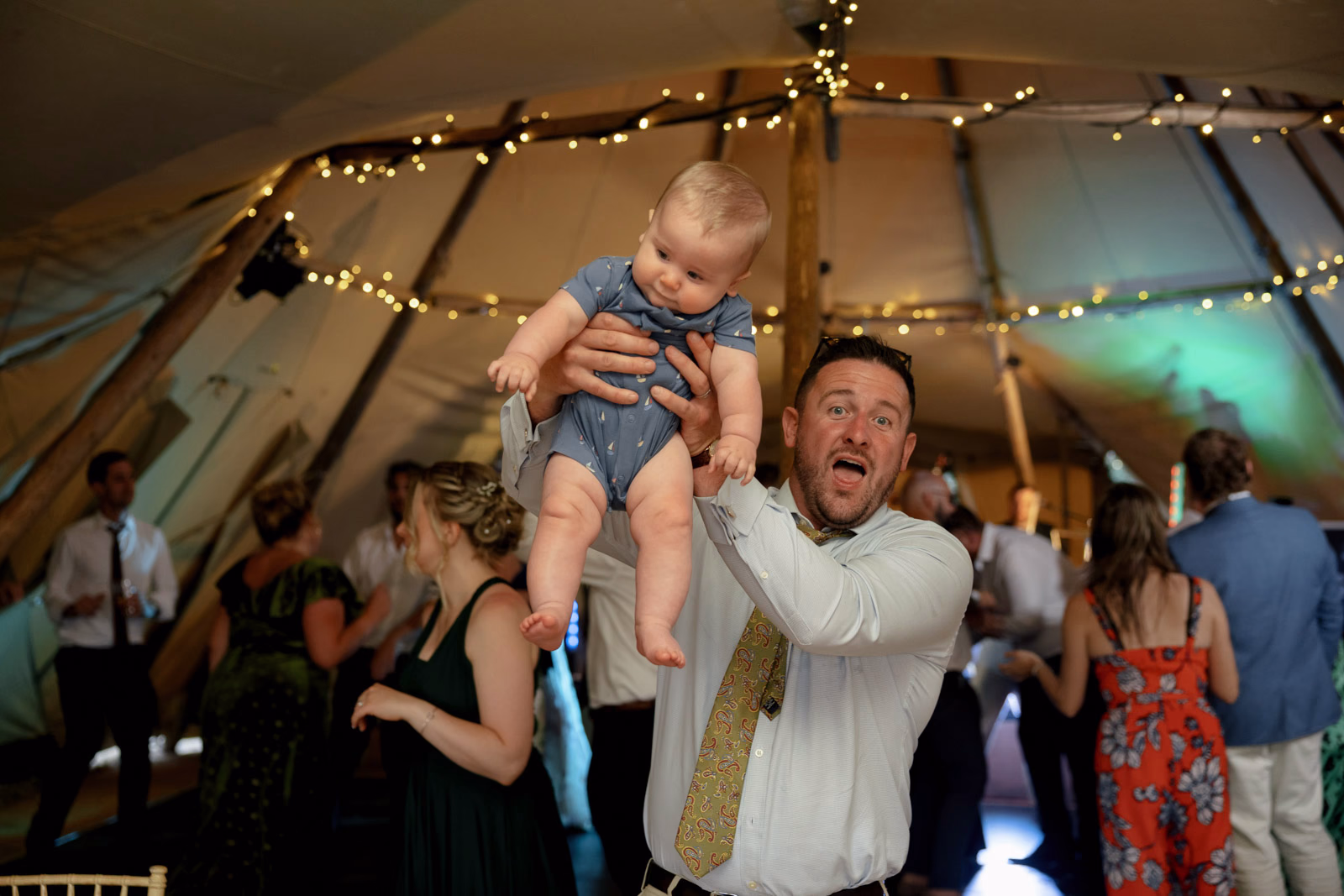Guest lifting baby on dancefloor at a countryside wedding in Taunton, Somerset