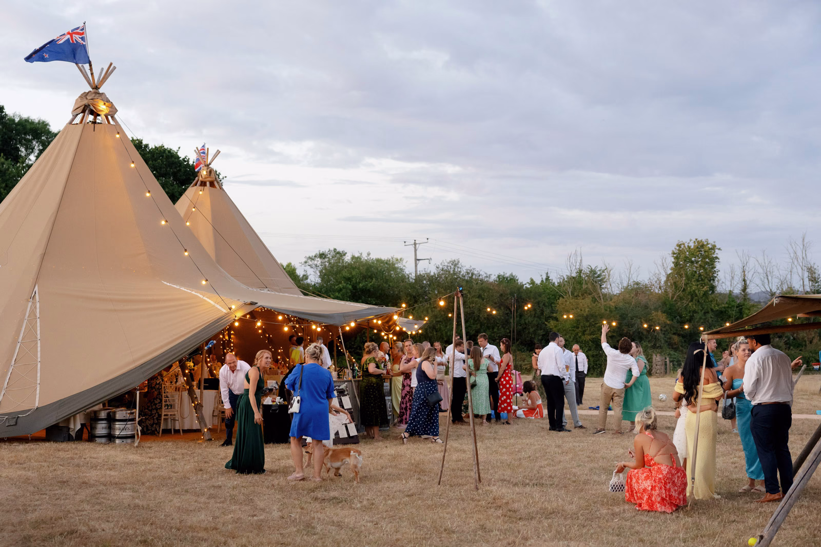 Tipi dusk guests gathering at a family farm wedding in Taunton