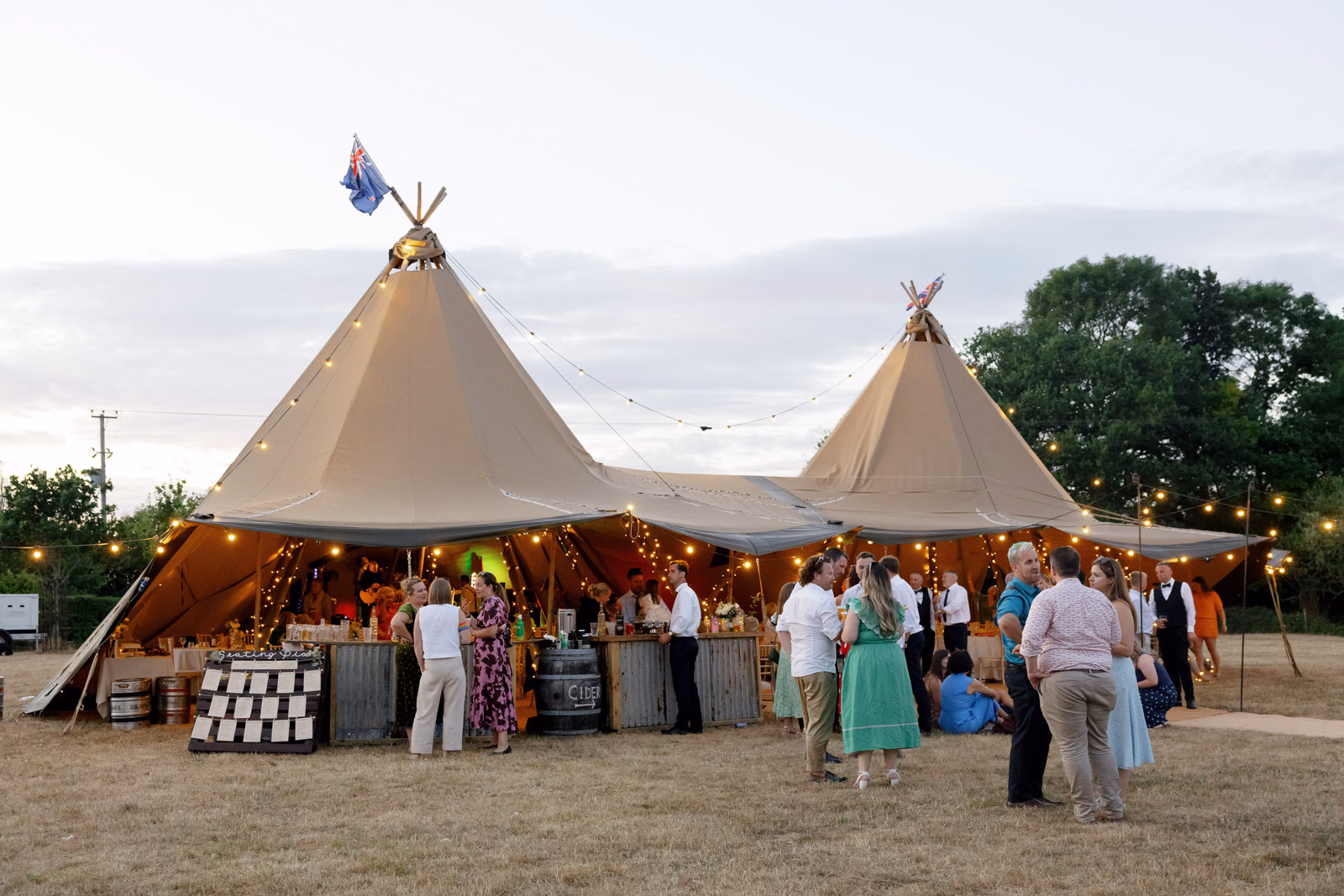 Tipi lit up at dusk at a family farm wedding in Taunton